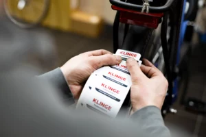 Fietsenmaker en verkoper Klinge tweewielers plakt stickers op rol op de achterkant van een fiets